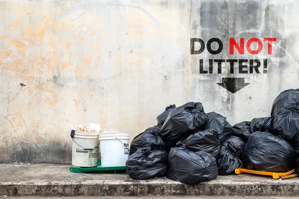 do not litter. black garbage bag with old brick wall background