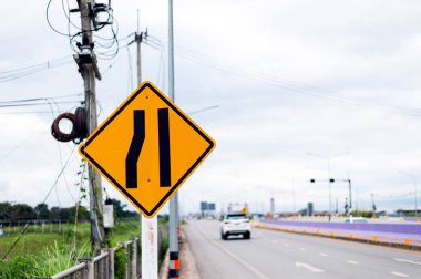 Trafik işaretleri, yol sol ile yumuşak odak ve ışık içinde belgili tanımlık geçmiş üzerinden daraltır