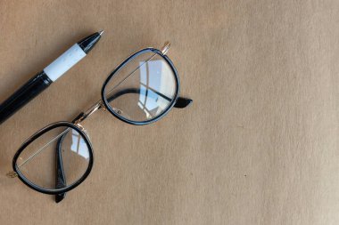 closeup eski gözlük ve kalem tablo yumuşak odak ve ışık içinde belgili tanımlık geçmiş üzerinden açık kitap üzerine