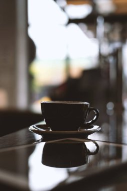 yumuşak odaklı ve arka planda ışık üzerinde kahve dükkanında sıcak kahve fincanı