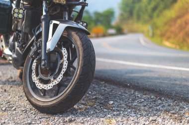 Arka planda hafif odaklı ve ışığın üzerinde duran büyük motorun yakın çekim lastiği