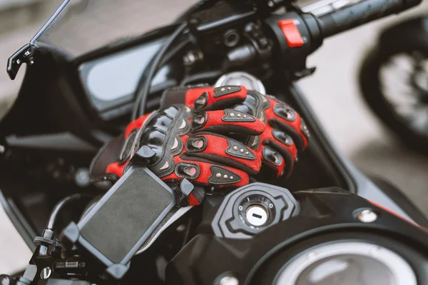 closeup driving gloves on bigbike with soft-focus and over light in the background