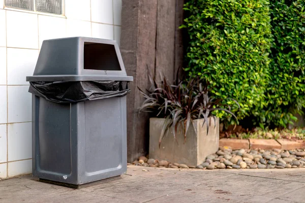 closeup gray trash bin with soft-focus and overlight in the background