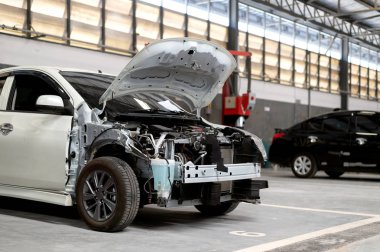 Garaj servis istasyonunda, arka planda hafif odaklı ve ışığın üzerinde kapalı araba tamiri