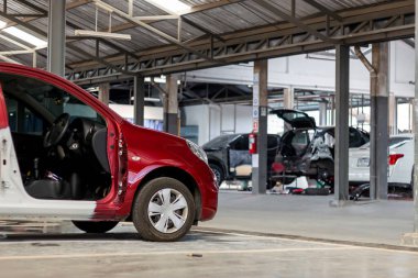 Arka plandaki ışığın üzerinde ve yumuşak odaklı kırmızı arabanın yeniden boyanmasını bekliyor.