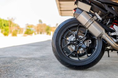 Yakın çekim lastik ve egzoz boru spor motosiklet yumuşak odaklı ve arka planda ışık üzerinde