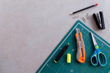 Çimento masasının arka planında kırtasiye ve ofis malzemeleri var. en üstteki görünüm