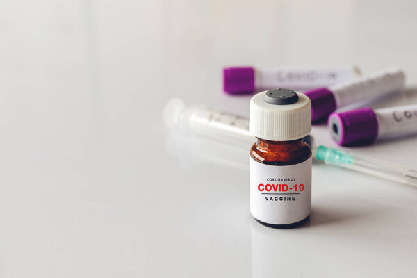 вакцина против коронавируса крупным планом (COVID-19) с мягкой фокусировкой и над светом на заднем плане
