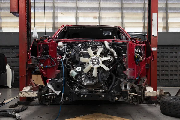 Otomobil tamirhanesinde hafif odaklı ve arka planında ışık olan bir araba.