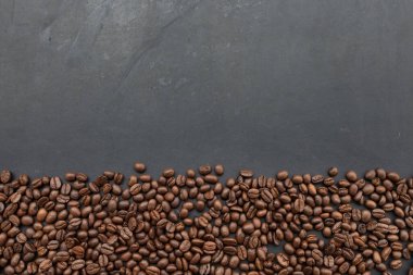 Kahve çekirdekleri siyah tahta masa arkaplanında. en üstteki görünüm