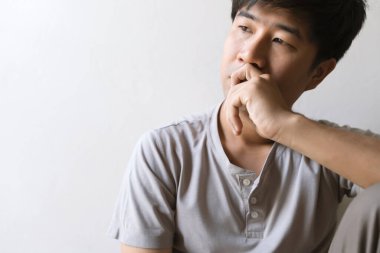 Yalnız başına oturan yakın plan bir pişmanlık ya da korku hisseden ve elini yüzünü odaya daldıran adam. yumuşak odaklı ve arka plandaki ışığın üzerinde