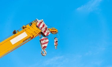 closeup yellow truck crane in construction site with soft-focus and over light in the background