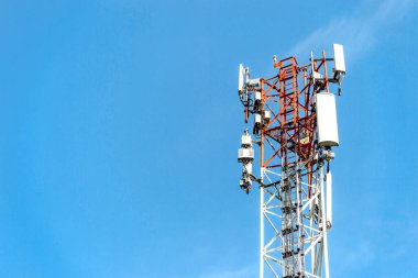 closeup telecommunications tower on blue sky with soft-focus and over light in the background