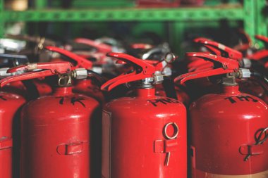 Yakın plan kırmızı yangın söndürücü, yumuşak odaklı ve arka planda ışık var.