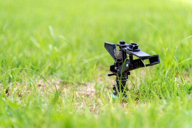 closeup water springer in garden with soft-focus and over light in the background