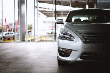 closeup white car in showroom with soft-focus and over light in the background