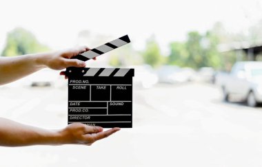 closeup man hands holding film clapper with soft-focus and over light in the background