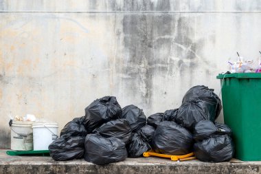 Eski tuğla duvarlı siyah çöp torbası.