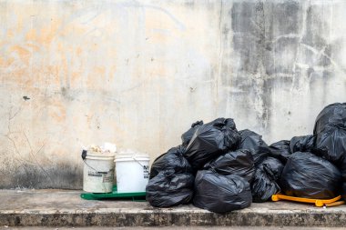 Eski tuğla duvarlı siyah çöp torbası.