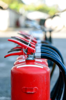 closeup red fire extinguisher with soft-focus and over light in the background clipart