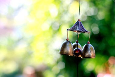 Tapınaktaki ağaçta asılı duran altın çan yumuşak odaklı ve arka plandaki ışığın üzerinde