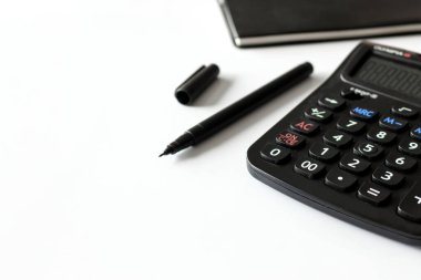 metin alanı, siyah kitap ve hesap makinesi olan ofis işyeri beyaz masa üzerinde yumuşak odaklı ve arka planda ışık üzerinde