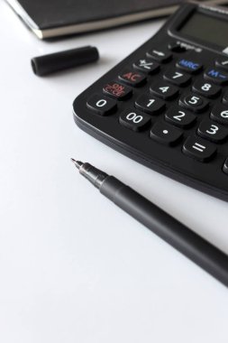 metin alanı, siyah kitap ve hesap makinesi olan ofis işyeri beyaz masa üzerinde yumuşak odaklı ve arka planda ışık üzerinde
