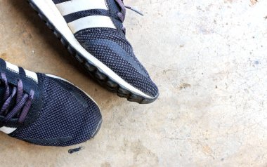 Yakından erkek ayakkabıları çimento zeminde, üst manzarada ve ışıkta.