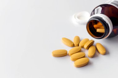 Beyaz masadaki C vitamini tabletlerini kapatın. Yumuşak odaklı ve hafif arkaplanlı.