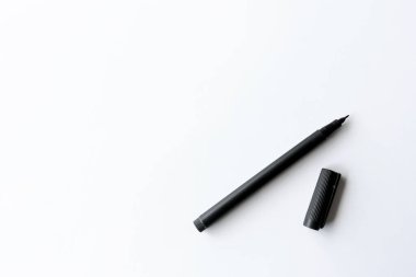 Kalem beyaz masada, arka planda ışık var.