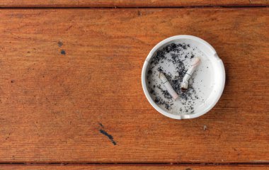 Yakın plan beyaz kül tablası ahşap üzerinde ışık altında