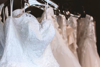 Yakın plan beyaz gelinlik, yumuşak odaklı ve arka planda ışık var.