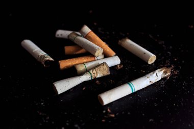 Dünya tütün günü konsepti yok. Sigaralar arka planda yumuşak odaklı siyah ahşap masa üzerinde. ışık üzerinde