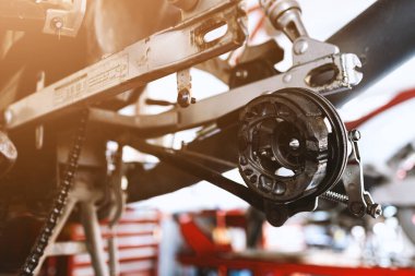 Motosikletin arkasındaki disk frenlerini tamir et. yumuşak odaklı ve arka plandaki ışığın üzerinde