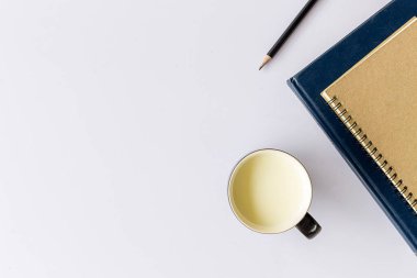 Bir fincan süt ve kitap arka planda yumuşak odaklı beyaz ahşap masa üzerinde. ışığın üzerinde. stilsel kırsal.