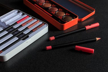 makyaj malzemeleri siyah masa arkasında, ışığın üzerinde, üst görünümde