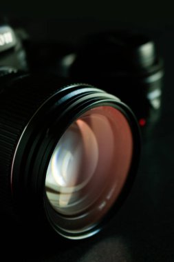 Arka planda yumuşak odaklı siyah ahşap masa üzerinde yakın çekim dijital kamera. koyu renk tonu ve açık renk