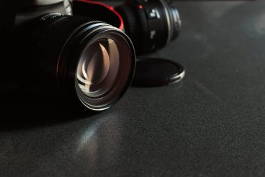 Arka planda yumuşak odaklı siyah ahşap masa üzerinde yakın çekim dijital kamera. ışık üzerinde