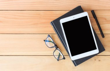 tablet bilgisayar ve kitap arka planda ışık ile ahşap tahta üzerinde