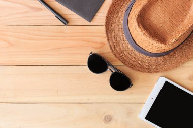 Plaj aksesuarları ve tablet bilgisayarı arka planda ışığın üzerinde.