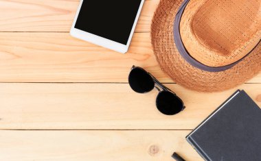 Plaj aksesuarları ve tablet bilgisayarı arka planda ışığın üzerinde.