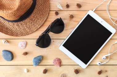 Plaj aksesuarları ve tablet bilgisayarı arka planda ışığın üzerinde.