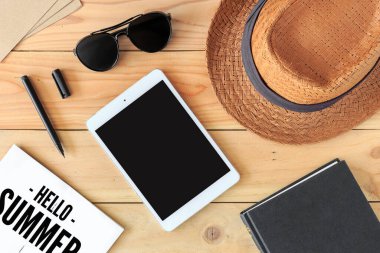 Plaj aksesuarları ve tablet bilgisayarı arka planda ışığın üzerinde.