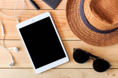 Plaj aksesuarları ve tablet bilgisayarı arka planda ışığın üzerinde.