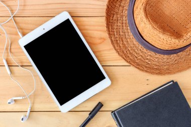 Plaj aksesuarları ve tablet bilgisayarı arka planda ışığın üzerinde.