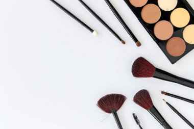 Makyaj malzemeleri beyaz masa arka planında metin alanı, ışık üzerinde, üst görünümde
