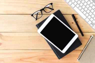 Metin alanı olan ofis çalışma yeri, ofis malzemeleri ile ahşap masa tablet, masaüstü bilgisayar ve kitap, üst görünüm, ışık üzerinde