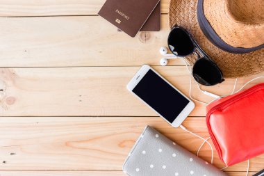 Tatillerdeki modern genç bayan ya da kızın en önemli manzarası. Ahşap zemin üzerinde kadınların yaz tatili aksesuarları. Işığın üstünde