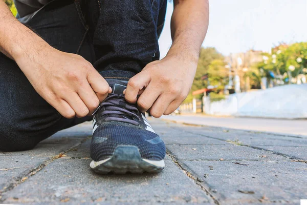Bir Adam Spor Ayakkabılarını Arka Planda Yumuşak Bir Odak Ile — Stok fotoğraf