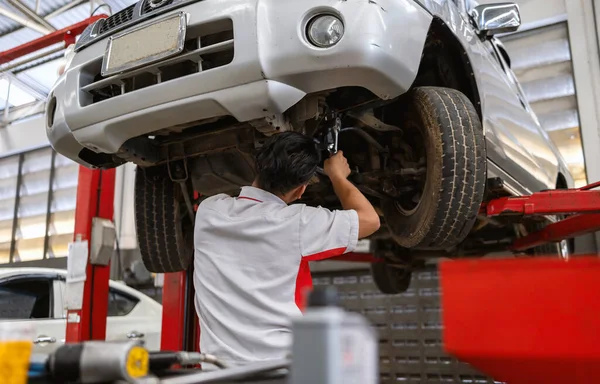 Механіка Фіксує Підвіску Автомобіля Яким Фокусом Світлом Фоні — стокове фото